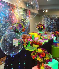 there are many balloons and flowers on display at the party table with confetti