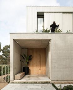 a woman standing on top of a concrete structure next to a planter filled with potted plants