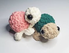 two stuffed animals sitting next to each other on a white surface with one holding the other's head