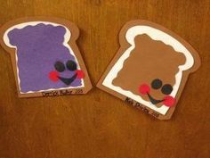 two pieces of paper cut to look like toasters with faces painted on them, one is brown and the other is purple