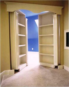 an open door leading into a room with shelves on either side and blue painted walls