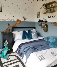 a child's bedroom with dinosaur wall decals on the walls and bedding