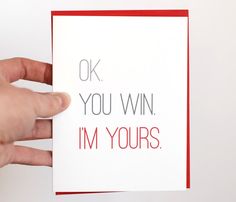 a hand holding a card that says ok you win i'm yours