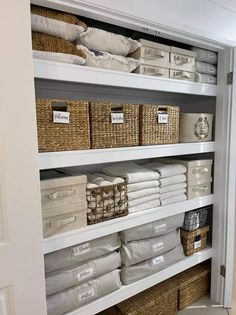 an organized closet with baskets and linens