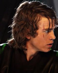 a young man with long hair wearing a star wars costume and staring at something in the distance