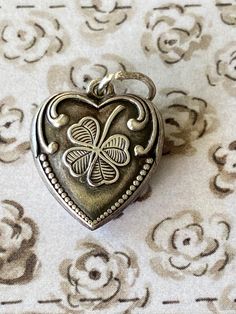 Antique Sterling Heart  Vintage  Sterling Heart  Sterling Heart with Shamrock and Flourishes   Sterling Mark on Back  This charm came from an estate and she had collected sterling charms since her childhood, beginning with 1920 and finishing her collection about 1960  She would often have the name and date of the person that either gave her the charm or was with her when she found the charm engraved on the back  This puffy heart charm was formed with the repousse method, one side is the design and the back is plain except for the engraving and the sterling mark.  Design is on front :  Shamrock and Flourishes  Sterling mark on back    It measures 1/2  inches tall  Needs a jump ring. Great condition - shows to have been worn, you may want to polish it.  Marked sterling on the back. I have no Puffy Heart Charms, Heart Vintage, Puffy Heart, Jump Rings, Family Gifts, On Back, Heart Charm, Charms, Accessory Gift