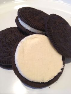 three oreo cookies with cream filling on a plate