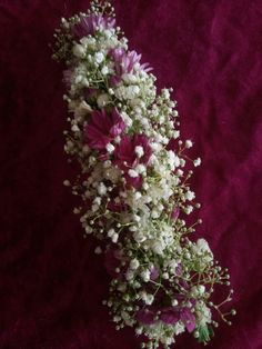 a bunch of flowers that are sitting on a purple cloth with white and pink flowers