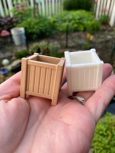 a small plastic trash can sitting in someone's hand