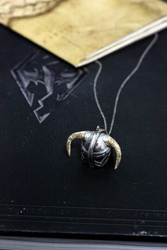 a necklace with an animal's head and horns on it sitting next to a card