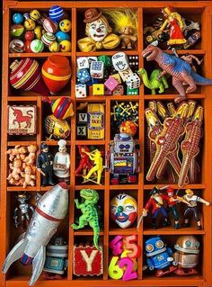 an orange wooden box filled with lots of toy figurines and other items in it