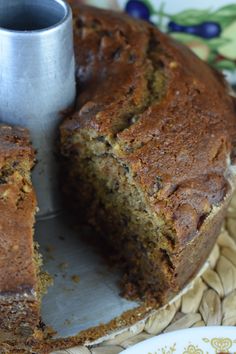 a loaf of banana bread on a plate with a slice cut out and ready to be eaten