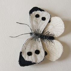 a white and black butterfly is hanging on the wall