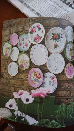 there are many plates on the wall with flowers in front of them and one is empty