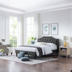 a bedroom with white walls and hardwood floors, furniture and decor on the floor is shown