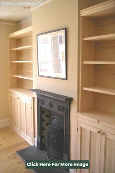 an empty living room with bookshelves and fireplace