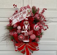 a christmas wreath with candy canes and a nutcracker on the front door