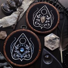 two black and white embroidered hoops on top of a table next to other items