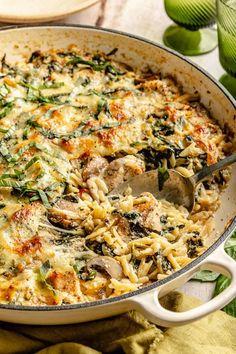 a casserole dish with spinach, mushrooms and cheese