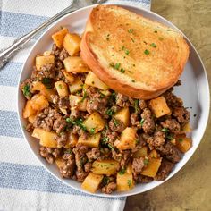 a white bowl filled with meat and potatoes on top of a blue and white checkered table cloth