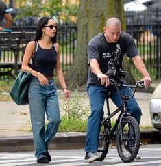 a man riding a bike next to a woman