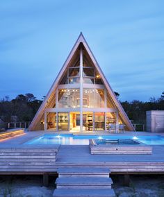 a house that has a pool in front of it and is lit up at night