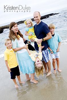 a family posing for a photo on the beach