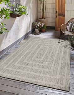 an outdoor area rug on the porch with potted plants