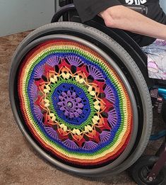 a man sitting in a wheel chair with a crocheted design on the side