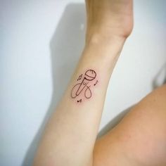 a woman's arm with a small tattoo on it