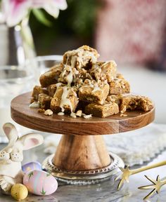 a wooden platter filled with marshmallows next to an easter bunny figurine