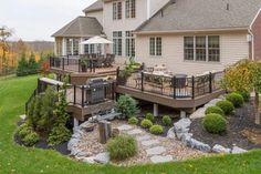 a large house with a deck and patio in the middle of it's yard