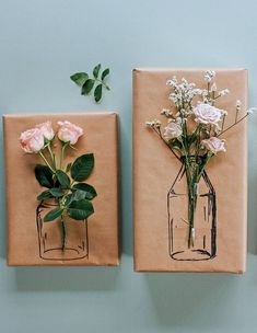 two vases with flowers are on brown paper and one has pink roses in it