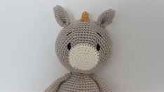 a crocheted stuffed animal sitting on top of a white wall