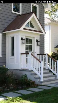 a house with white trim and stairs leading up to the front door