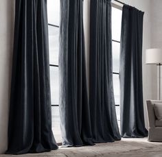 a living room with blue drapes hanging from the ceiling and a chair in front of it