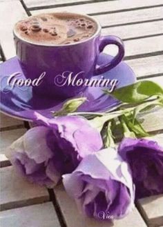 a cup of coffee and some purple flowers on a wooden table with the words good morning