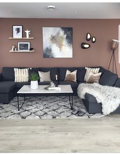 a living room with grey couches and white rugs on top of the floor