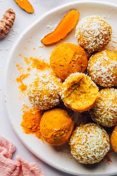 a white plate topped with lots of different types of pastries next to orange peels