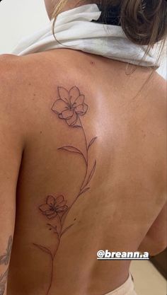 a woman with a flower tattoo on her back