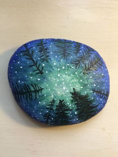 a painted rock sitting on top of a wooden table