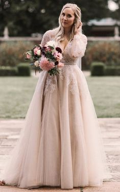 a woman in a wedding dress is standing outside