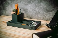 a desk with a pen holder and pencils on it