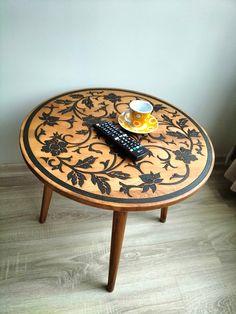 a coffee table with a remote control on it next to a cup and saucer