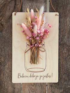 a mason jar with flowers in it hanging on a wooden sign that says bakeu dobrege gestas