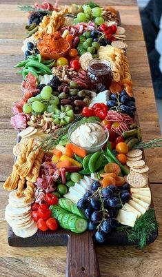 a long platter filled with lots of different types of food on top of a wooden table