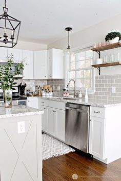 a large kitchen with white cabinets and wood floors is pictured in this image from the front view