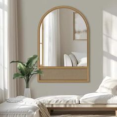 a living room with white furniture and a large mirror on the wall above the couch