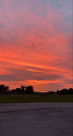 an airplane is flying in the sky at sunset or sunrise with red and orange clouds