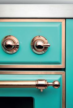 an oven with two knobs on the front and one door open, in teal green